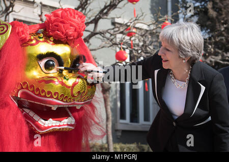 Premier ministre Theresa peut 'Dots' l'œil d'un dragon chinois, un rituel traditionnel de l'éveil d'un dragon, dans l'enceinte de l'ambassade britannique à Beijing aujourd'hui le deuxième jour de trois jours de mission commerciale en Chine. Banque D'Images