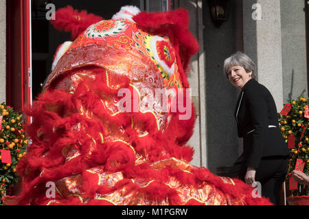 Premier ministre Theresa peut 'Dots' l'œil d'un dragon chinois, un rituel traditionnel de l'éveil d'un dragon, dans l'enceinte de l'ambassade britannique à Beijing aujourd'hui le deuxième jour de trois jours de mission commerciale en Chine. Banque D'Images