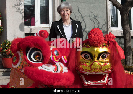 Premier ministre Theresa peut 'Dots' l'œil d'un dragon chinois, un rituel traditionnel de l'éveil d'un dragon, dans l'enceinte de l'ambassade britannique à Beijing aujourd'hui le deuxième jour de trois jours de mission commerciale en Chine. Banque D'Images