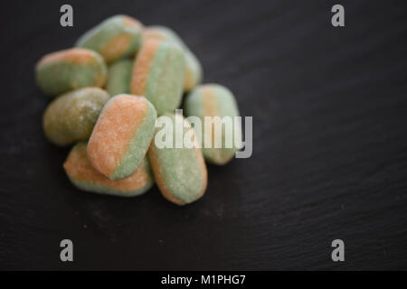 La nourriture de bonbons friandises ou sucre candy coated et bande de couleurs orange et vert et parfumé à la mangue et pomme Banque D'Images