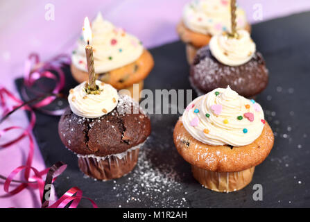 Fond d'anniversaire avec des muffins ou des petits gâteaux et des bougies. Table d'anniversaire ou fête fond parti avec décoration. Banque D'Images