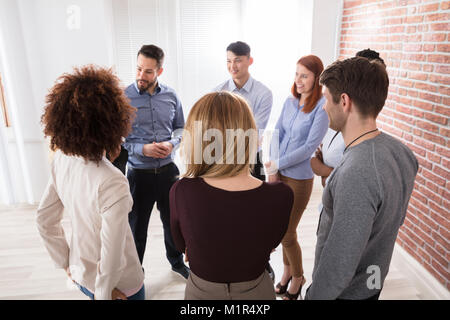 Manager avec ses collègues d'affaires ayant la discussion dans le bureau Banque D'Images