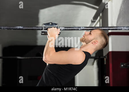 Portrait d'un athlète homme Pullup Poignée étroite exercice dans la salle de sport Banque D'Images