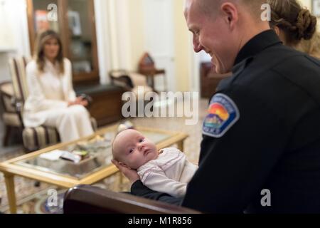 Agent de police d'Albuquerque Ryan Holets tient sa petite fille adoptée, l'espoir, comme la première dame des États-Unis Melania Trump hôtes invités avant le départ du président Donald Trump's premier état de l'Union à une session conjointe du Congrès au Capitole, le 30 janvier 2018 à Washington, DC. Banque D'Images