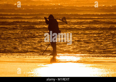 Blackpool, Lancashire, 1er févr. 2018. Météo britannique. Après une journée glaciale et venteuse, un metal detectorist tête sur une chasse au trésor dans la lumière dorée du coucher du soleil caressant les rives sur le front de mer de Blackpool, dans le Lancashire. Credit : Cernan Elias/Alamy Live News Banque D'Images