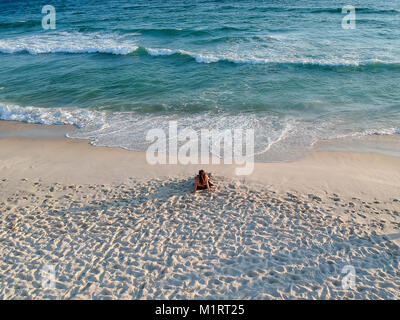 Drone photo d'une femme sur la plage pendant le coucher du soleil à Barra beach, Rio de Janeiro, Brésil Banque D'Images