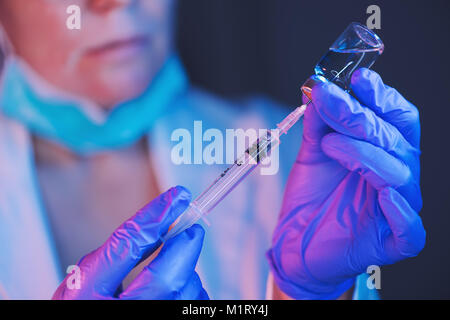 Médecin l'élaboration de solution à partir de bouteille et de remplissage seringue de vaccin pour l'injection de vaccination des patients en clinique médicale, santé et médecine profes Banque D'Images