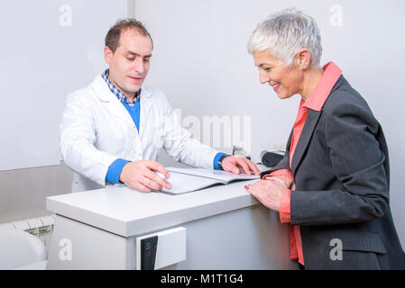 Dame âgée heureux de payer sa facture médicale Banque D'Images