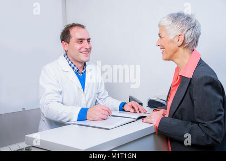 Dame âgée heureux de payer sa facture médicale Banque D'Images