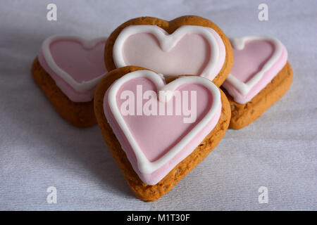 Gingerbread cookies en forme de cœur décoré de glaçage rose, un parfait Saint-valentin traiter Banque D'Images