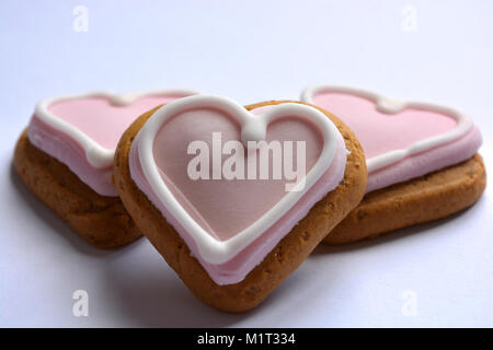 Gingerbread cookies en forme de cœur décoré de glaçage rose, un parfait Saint-valentin traiter Banque D'Images