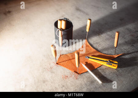 Close up of hands tanner effectue un travail sur table avec des outils Banque D'Images