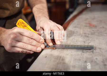 Close up of hands tanner effectue un travail sur table avec des outils Banque D'Images