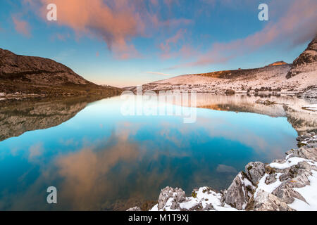 Pleine lune dans les lacs de Covadonga, dans les Asturies, où ses reflets dans l'eau, sa lumière, sa couleur, sur une nuit d'hiver, contraste avec la neige Banque D'Images