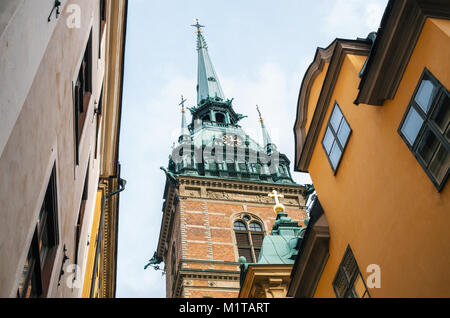 Vue d'angle de clocher de l'Église allemande Tyska kyrkan entre maisons à Stockholm, en Suède. Banque D'Images