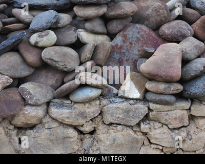 Grunge texture du mur de pierre : immense ovale naturel rose et gris des rochers irréguliers de mentir sur le dessus de l'autre. Banque D'Images