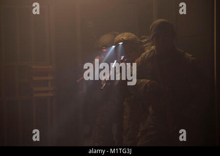 Les soldats de l'armée américaine avec la Garde nationale de la Virginie de l'Ouest se préparent à entrer dans une chambre claire et alors que la recherche de victimes dans le cadre de la formation d'assistant médical de combat le 25 janvier 2018 à l'Espace Formation Volkstone Camp, Dawson, W.Va. Au cours de cette formation, le scénario d'assistants médicaux de combat ont été portées aussi près que possible le champ de bataille, avec des bruits simulées, obstacles et vivre des jeux de rôle pour les mettre en situation de stress et de tester leurs compétences. (U.S. Air National Guard par Airman Caleb Vance) Banque D'Images