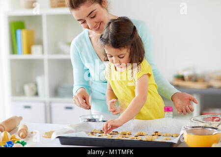 Happy mother and daughter making cookies à la maison Banque D'Images