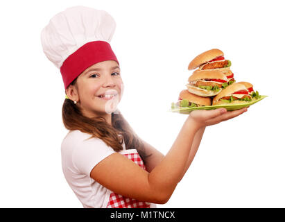 Happy little girl cook avec des hamburgers sur la plaque Banque D'Images