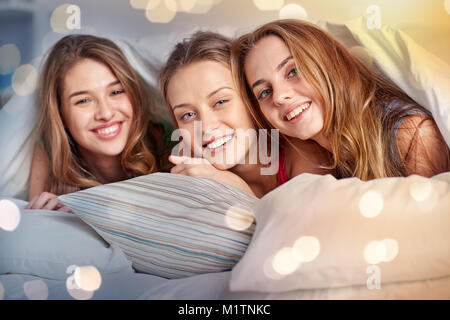 Heureux les jeunes femmes dans le lit à la soirée pyjama Banque D'Images