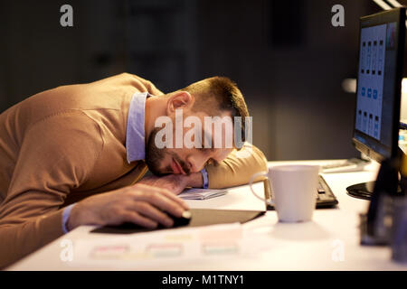 Homme fatigué dormir sur le tableau à l'office de nuit Banque D'Images