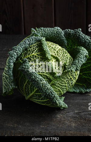 Chou de Milan sur une table en bois sombre. Banque D'Images