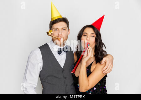 Couple heureux avec party blowers s'amusant Banque D'Images