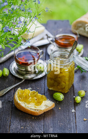 Confiture de groseille verte dans un pot sur une table en bois Banque D'Images