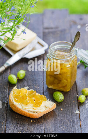 Confiture de groseille verte dans un pot sur une table en bois Banque D'Images