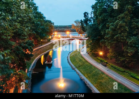 Canal de l'eau dans le parc de la ville avec les lumières et l'éclairage de nuit sur un pont de pierre menant à la rivière Sozh Banque D'Images