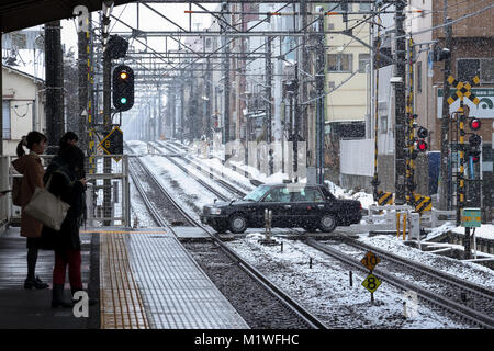 Tokyo, Japon. 2e Février, 2018. Un taxi est vu traversant la voie ferrée près de la gare à Musashi-Seki sous une chute de neige le 2 février 2018, Tokyo, Japon. Un deuxième coup de neige Tokyo commencent le 1er février et se poursuivant en journée, la 2ème, perturbant les transports publics pendant l'heure de pointe du matin. L'Agence météorologique japonaise avait annoncé que la neige ne sera pas aussi lourd que celui le 22 janvier. Credit : Rodrigo Reyes Marin/AFLO/Alamy Live News Banque D'Images