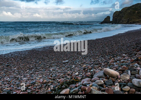 L'Aberdeenshire, Ecosse, Royaume-Uni. Les forts vents créer une poussée de la mer du Nord le long de la côte nord-est de l'Ecosse, avec de grandes vagues se brisant sur le rivage d'une plage de galets Banque D'Images