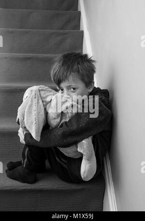 Sentiment d'abandon de l'enfant solitaire assis sur l'escalier. Banque D'Images