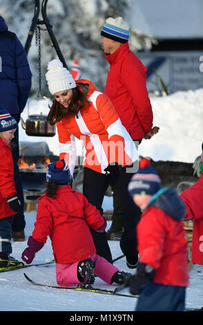La duchesse de Cambridge jusqu'à un enfant qui a baissé au cours de qu'elle assiste à un événement de Tryvann, Oslo, Norvège, organisé par le Fédération de ski norvégien, où elle et le duc de Cambridge a vu un groupe de pépinière locale les enfants prenant part à une session de l'école de ski de l'après-midi sur les pistes, le dernier jour de leur tour de Scandinavie. Banque D'Images