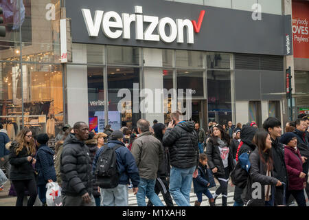 Les piétons traversent Herald Square en face d'un magasin Verizon Wireless à New York le samedi, Janvier 27, 2018. Verizon a annoncé récemment qu'elle s'attend à ce que la réforme fiscale d'ajouter entre 3,5 et 4 milliards de dollars pour sa trésorerie d'exploitation cette année. (© Richard B. Levine) Banque D'Images