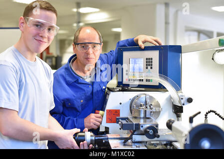 Portrait de l'enseignant et de l'apprenti dans la formation professionnelle à un tour cnc Banque D'Images