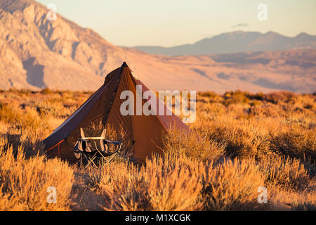 Le style indien tipi tente pliante chaise avec camp à proximité campèrent dans le désert sous les montagnes de la Sierra Nevada Banque D'Images