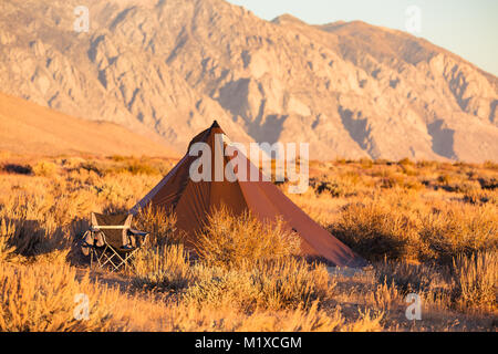 Le style indien tipi tente pliante chaise avec camp à proximité campèrent dans le désert sous les montagnes de la Sierra Nevada Banque D'Images