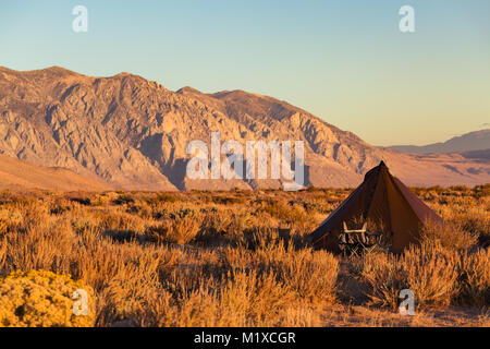 Le style indien tipi tente pliante chaise avec camp à proximité campèrent dans le désert sous les montagnes de la Sierra Nevada Banque D'Images