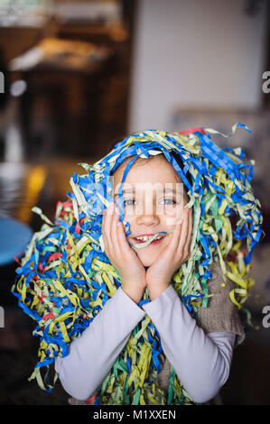 La petite fille avec des rubans autour du cou et de la tête pour le carnaval dans l'accueil Banque D'Images