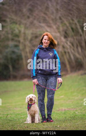 Petit chiot chien terrier avec sa femme propriétaire ina park UK Banque D'Images