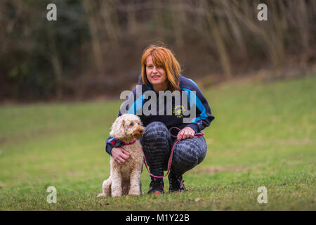 Petit chiot chien terrier avec sa femme propriétaire dans un parc Banque D'Images