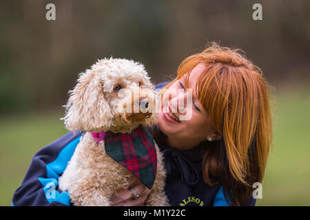 Petit chiot chien terrier avec sa femme propriétaire dans un parc Banque D'Images