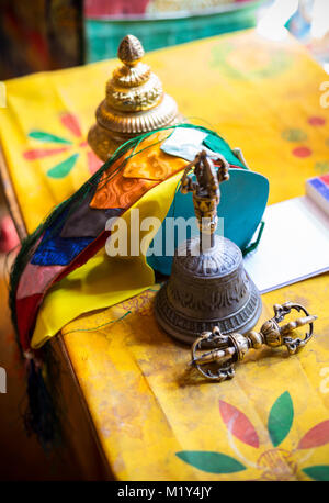 Paro, Bhoutan. Monk (Vajra Dorje) (mettre en oeuvre symbolisant la compassion et les moyens habiles), Bell, rubans, encens et sur son bureau au Temple. Banque D'Images