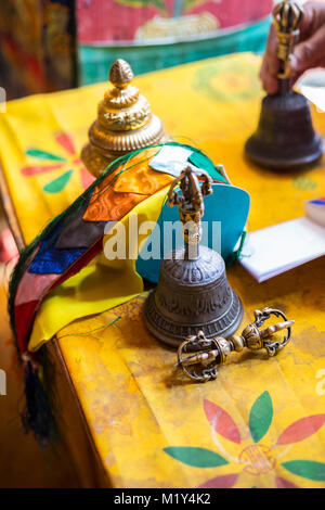 Paro, Bhoutan. Monk (Vajra Dorje) (mettre en oeuvre symbolisant la compassion et les moyens habiles), Bell, rubans, encens et sur son bureau au Temple. Banque D'Images