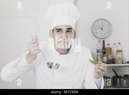 Mâle est degustating soupe sur cuisine. Banque D'Images