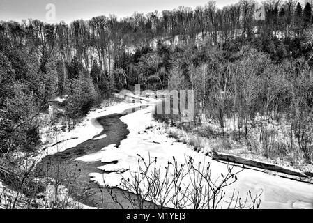Paysage d'hiver en noir et blanc - vue sur la forêt d'hiver et la rivière en courbe Banque D'Images