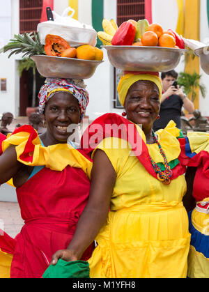 Cartagena, Colombie - Janvier 23th, 2018 : Portrait de deux palenqueras avec un panier métal avec fruits posant souriant à la vieille ville de Cartagena de J Banque D'Images