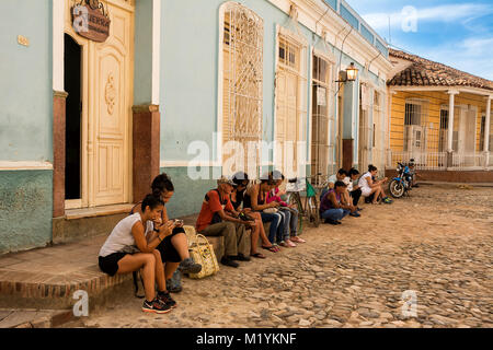 Trinidad, Cuba - 8 décembre 2017 : Les gens assis, le surf sur internet uniquement présent dans le carré en wi-fi Banque D'Images