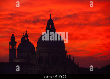 Sang rouge ciel coucher soleil sur la lagune de Venise avec dômes Basilique Salute Banque D'Images